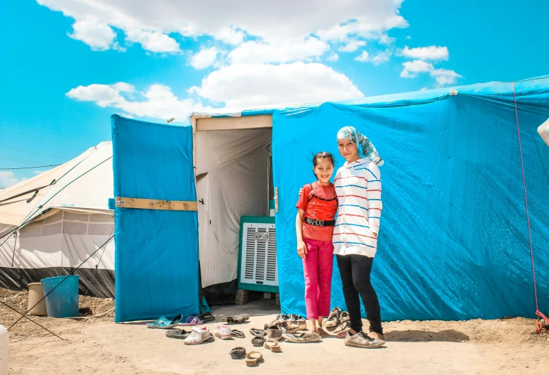 a man and a woman standing in front of a tent