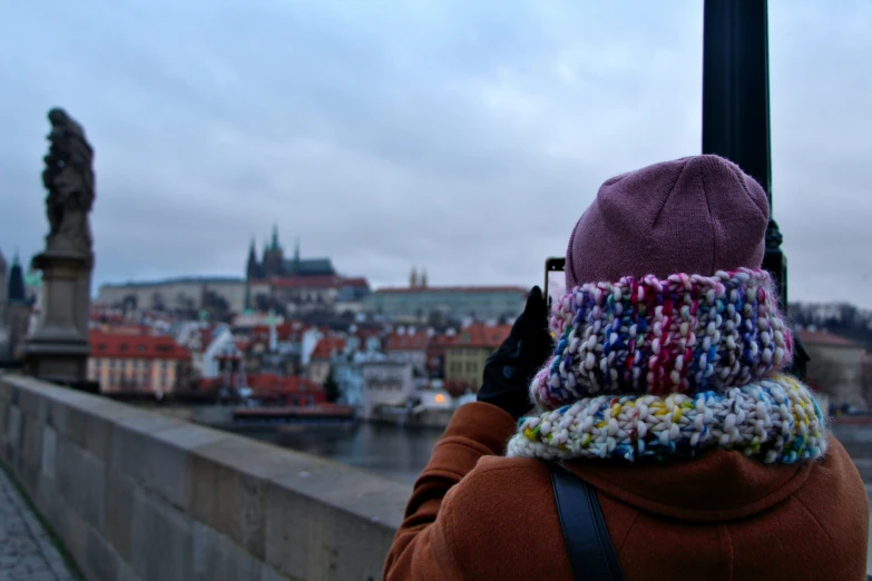 a woman is taking a picture of the view of the city
