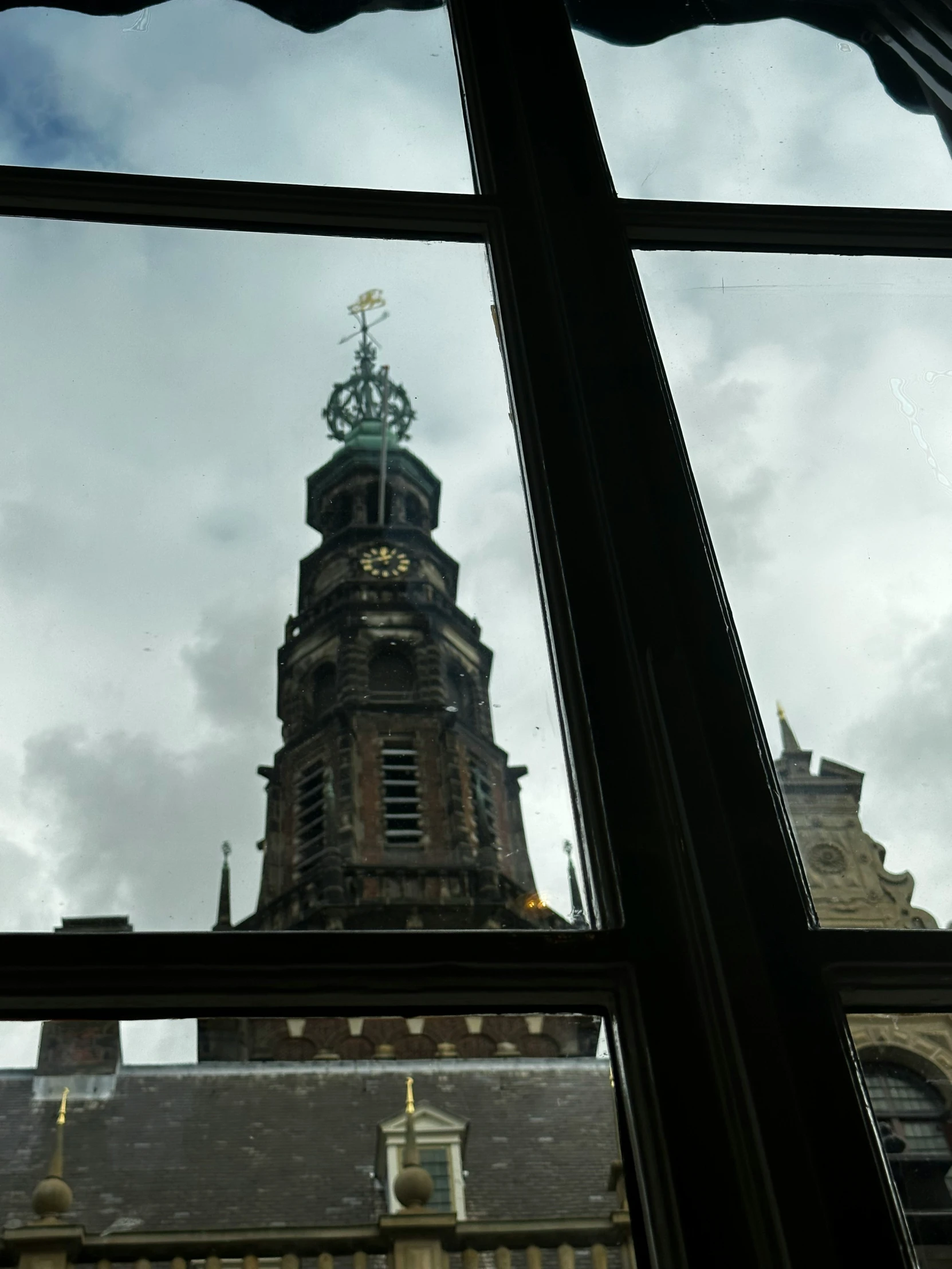 a clock tower behind a glass window in a building