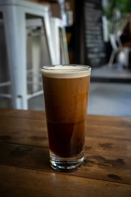 a glass of beverage with liquid in it sitting on a table