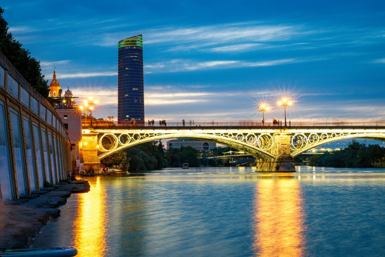 a bridge over the river with tall buildings in the background