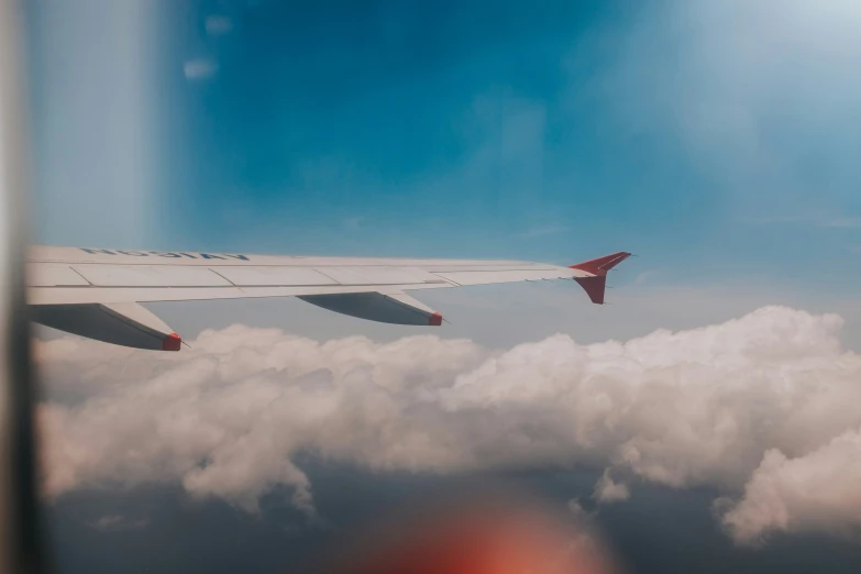 an airplane wing seen through the clouds