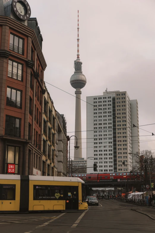 buses are parked outside a building near a television tower