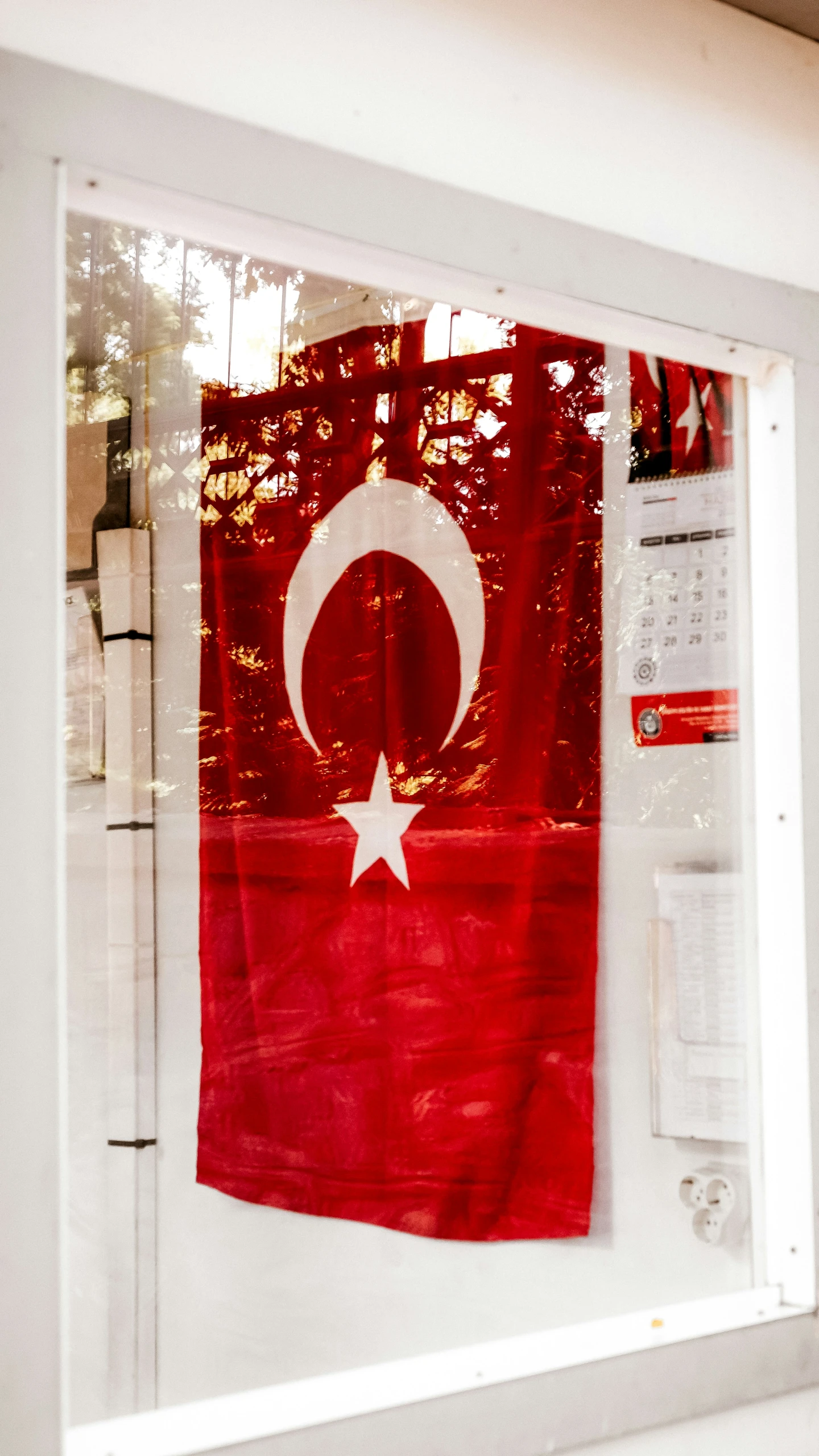 a flag hanging on the wall reflected in a window