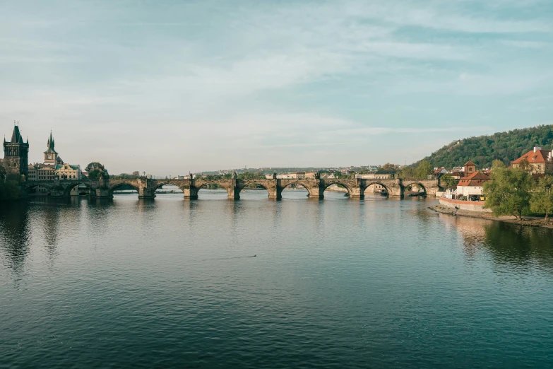 a bridge spanning across a river next to a castle