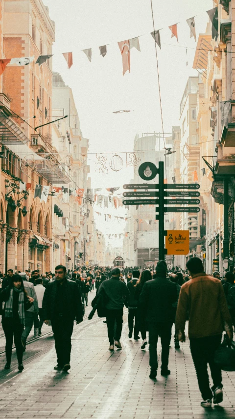 people walk through a busy downtown area in the sun