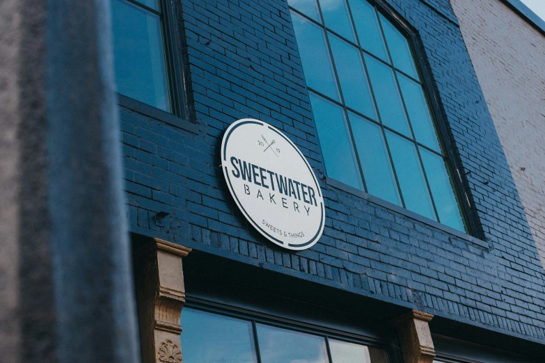 a brick building with glass windows and a logo for sweet potato