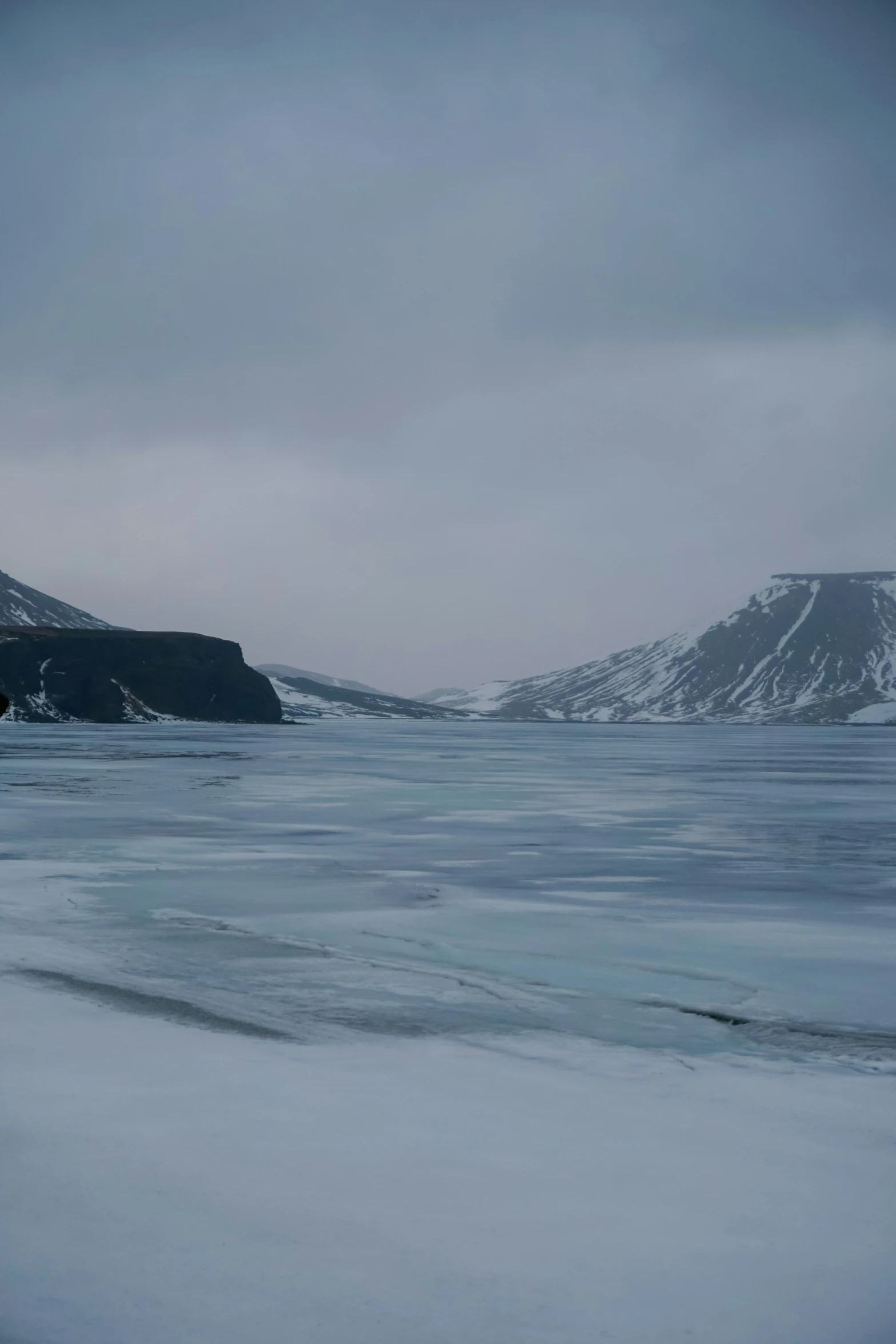 a view of the snow covered mountains, from the ocean