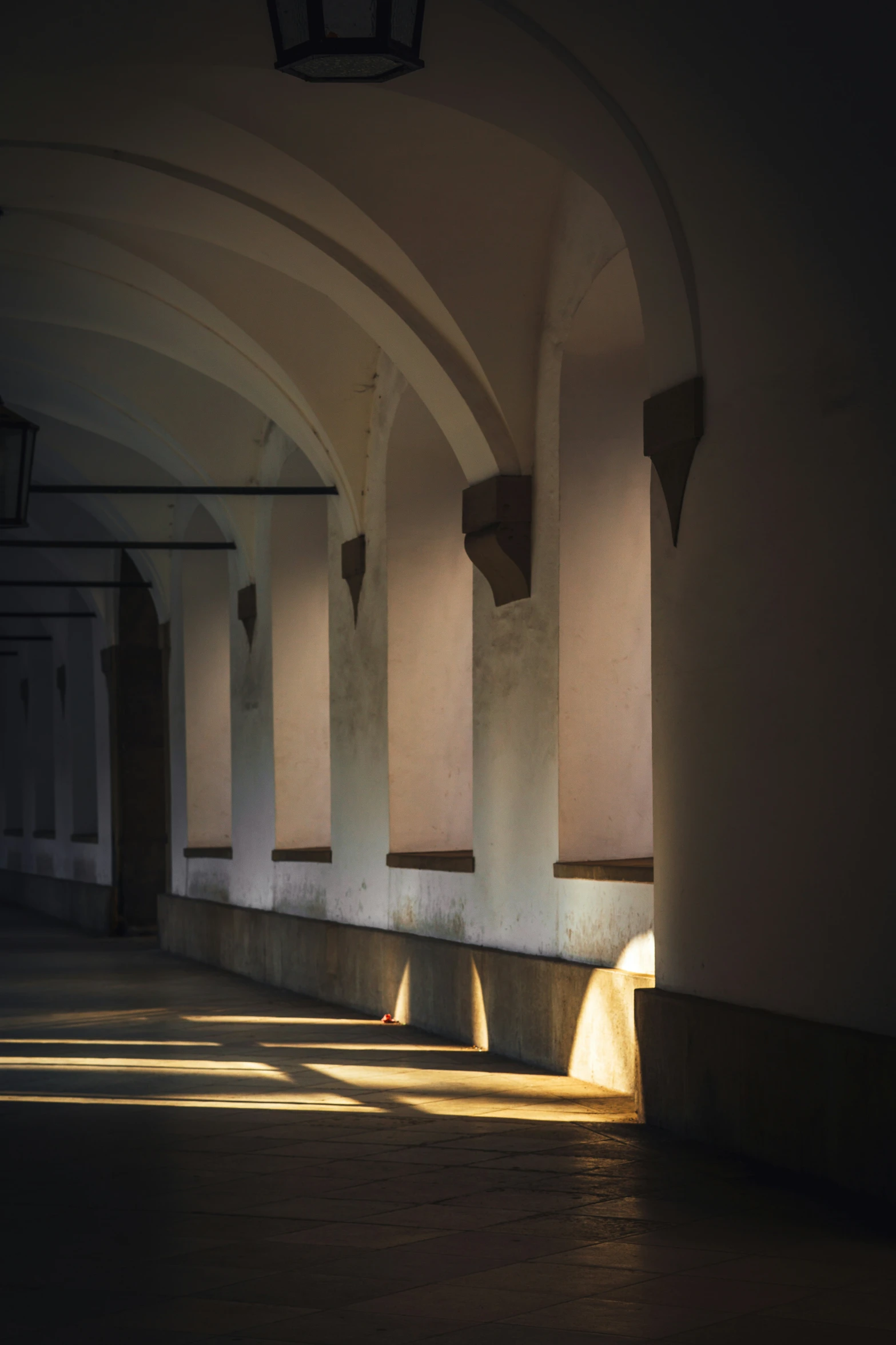 light coming in through the beams of an archway on a building