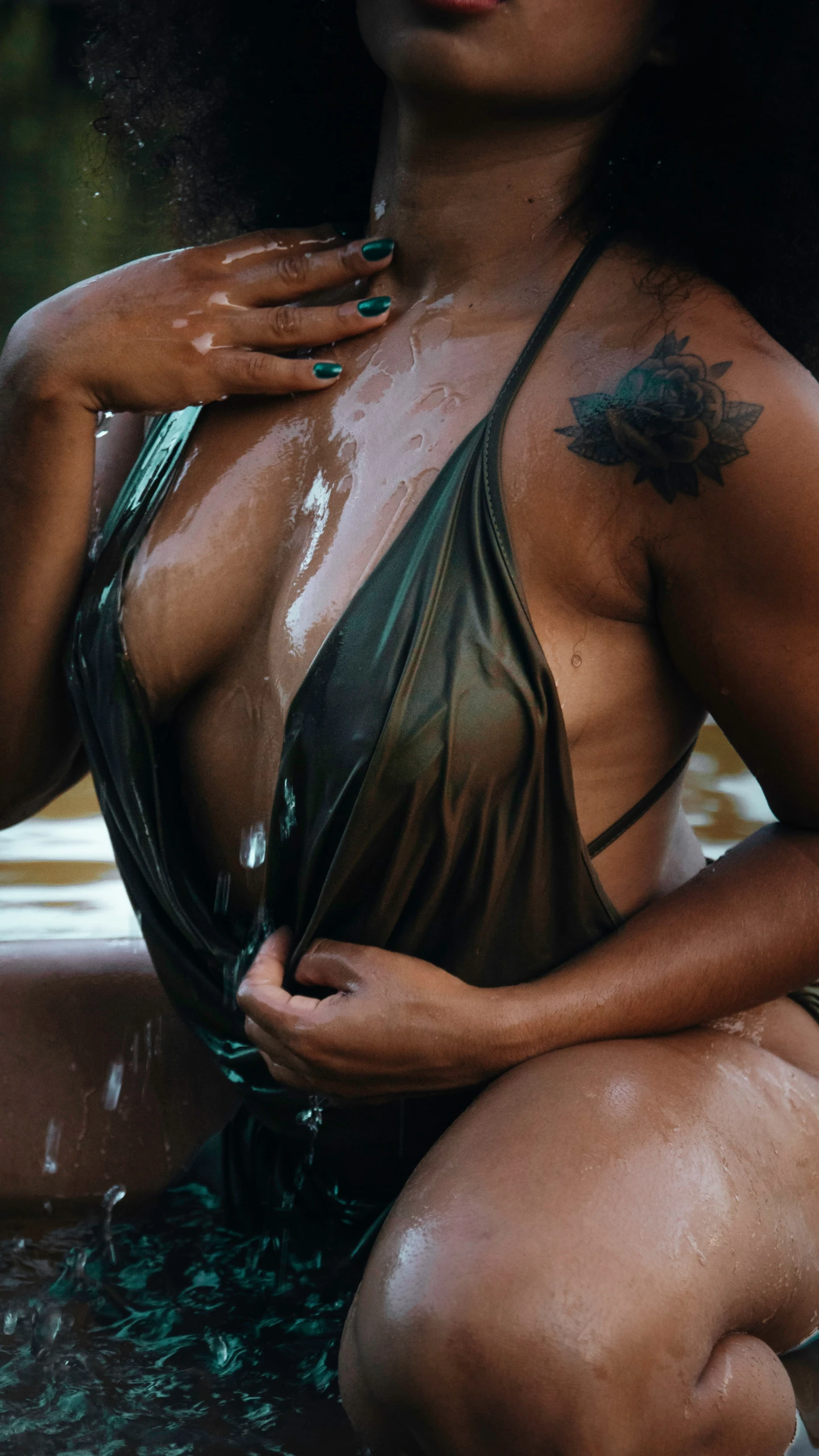 a woman is sitting in a fountain and covered with water