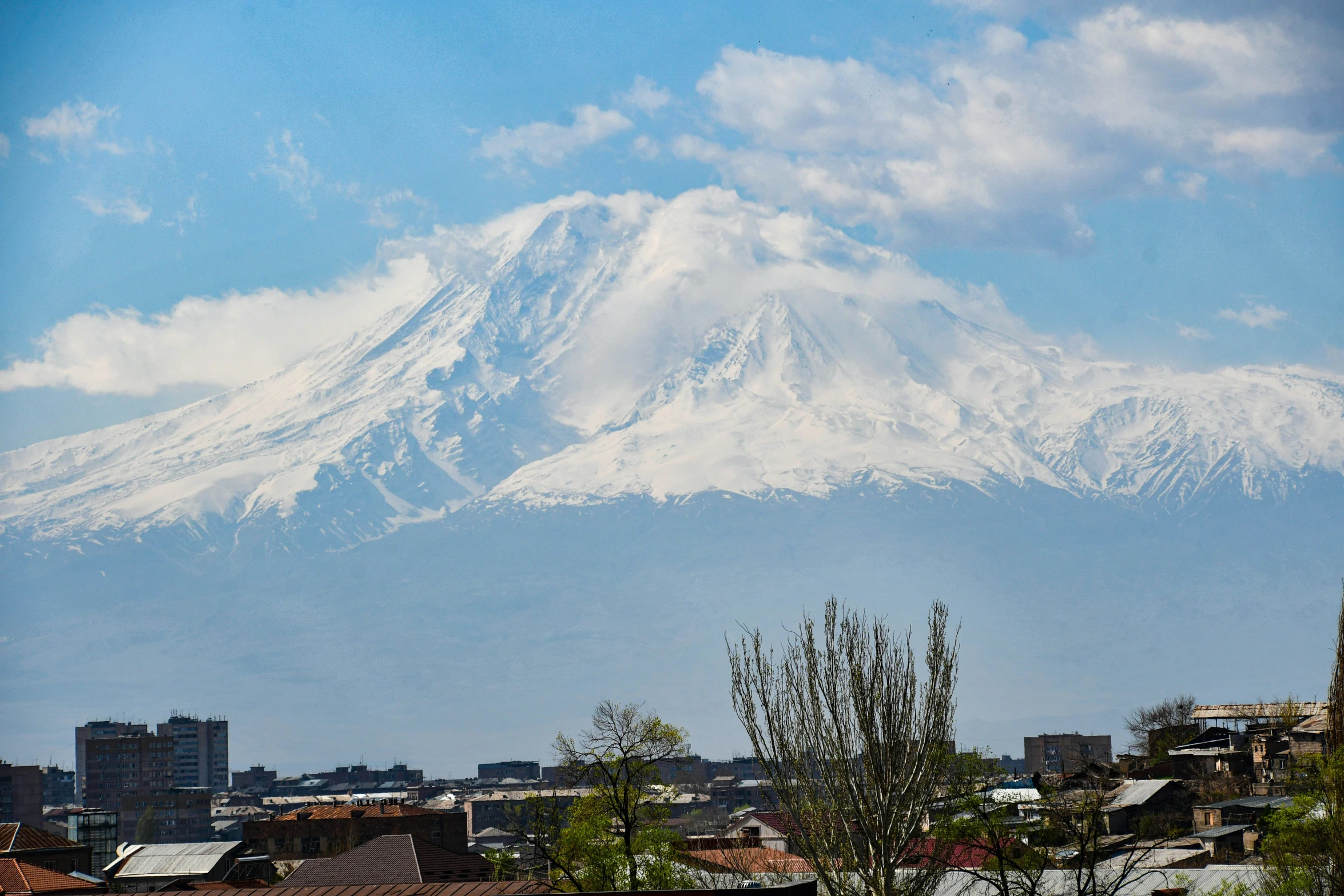 a mountain rises over a city in a bright, sunny day