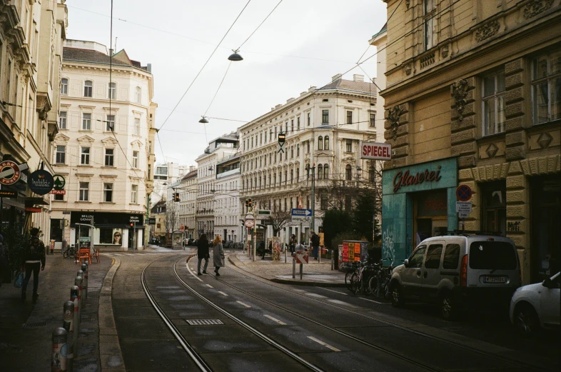 a man walking down the road with several cars and people