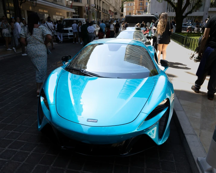 this blue sports car is parked on the sidewalk