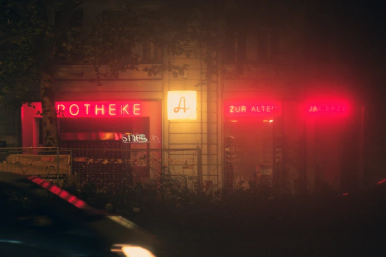 a sign on the side of a building with red lights in the street