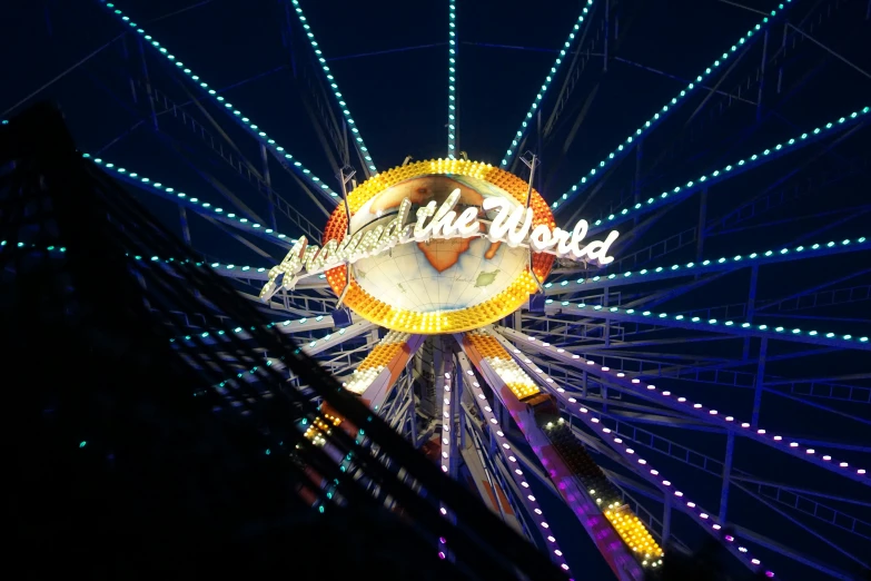 the ferris wheel is lit up in a night scene