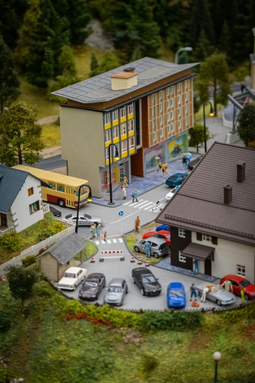 a miniature town is shown with buildings, cars and busses