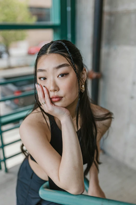 a young asian woman posing in front of a window