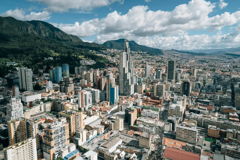 a large cityscape that has tall buildings and mountains