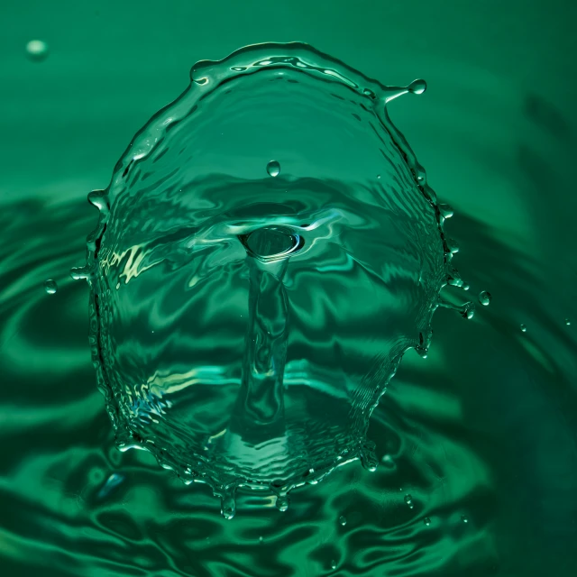 the droplets of the green water are creating a circular formation
