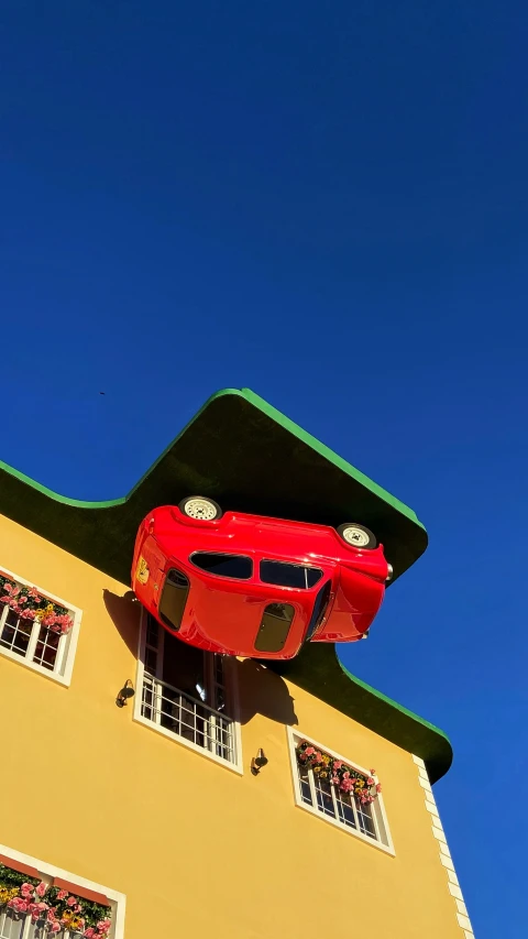 a car suspended over a building with windows