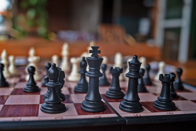 a large black chess set on a chess board