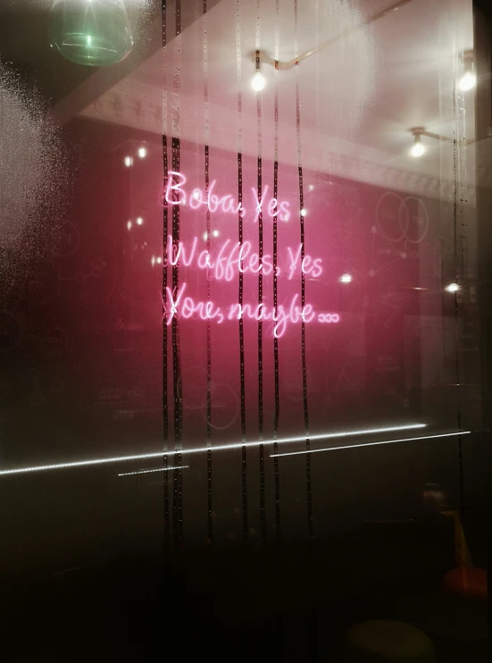 neon text written on the window of a salon