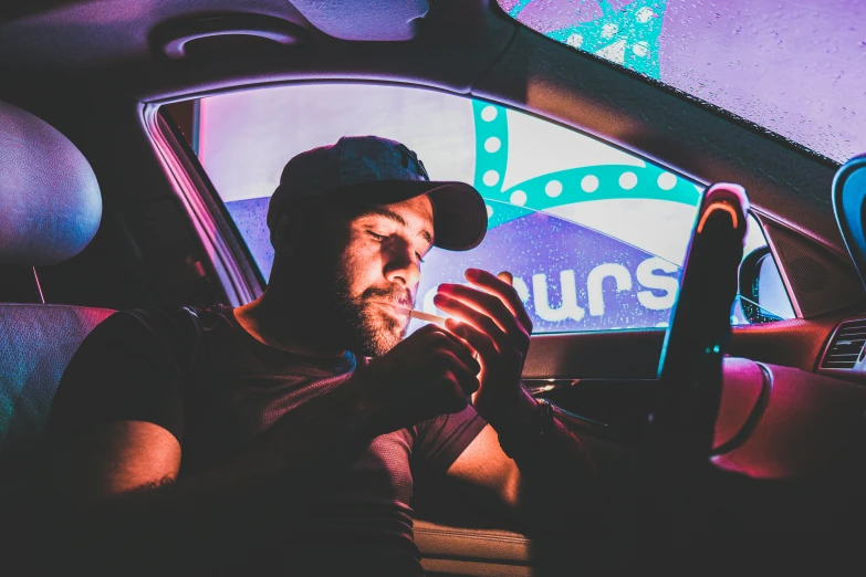 a man is sitting in his car using a phone