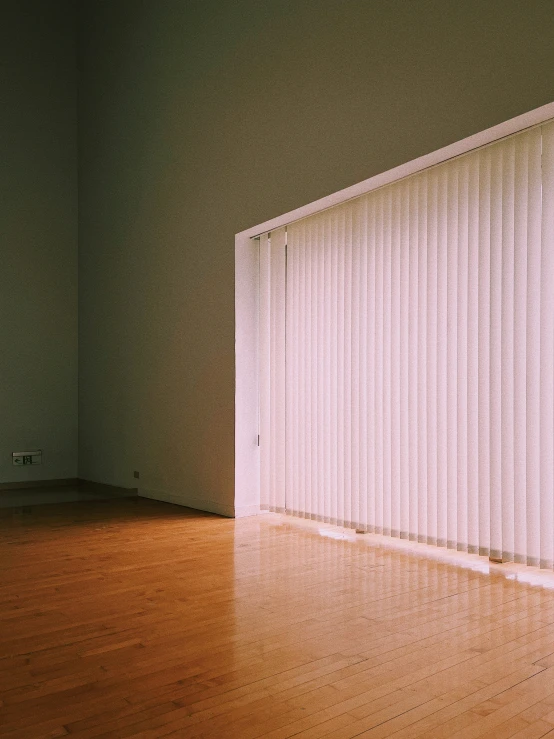 a plain room with a door and large blinds