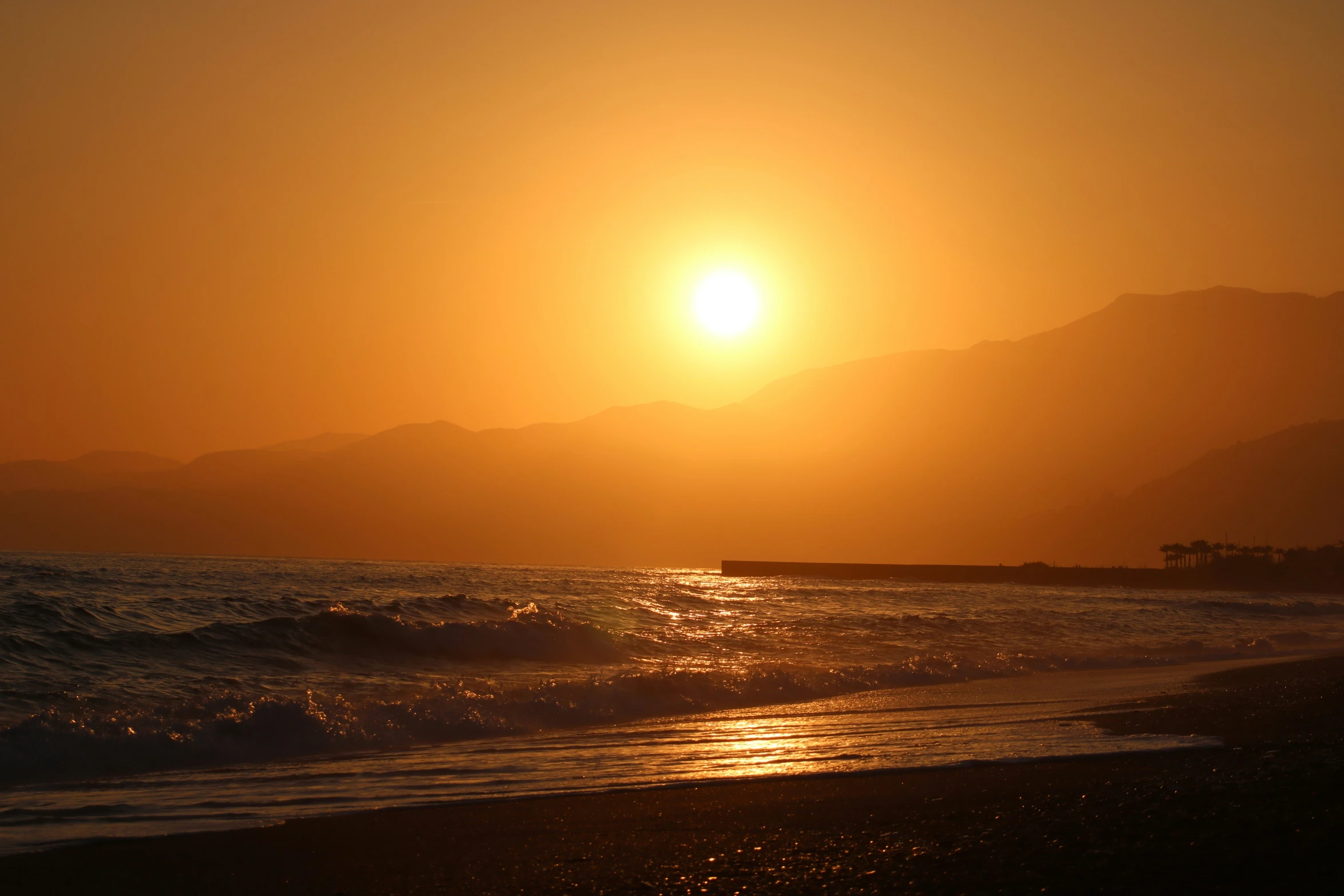 a sunset on the beach with ocean waves