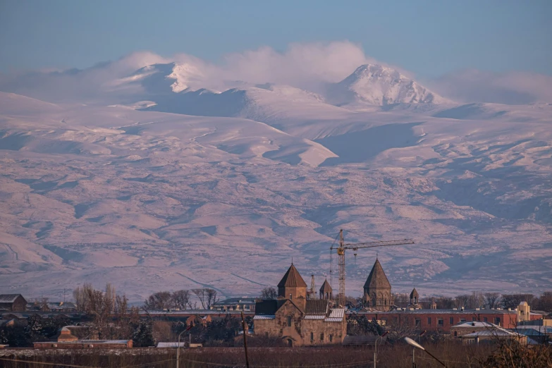 a mountain view with buildings and hills in the background