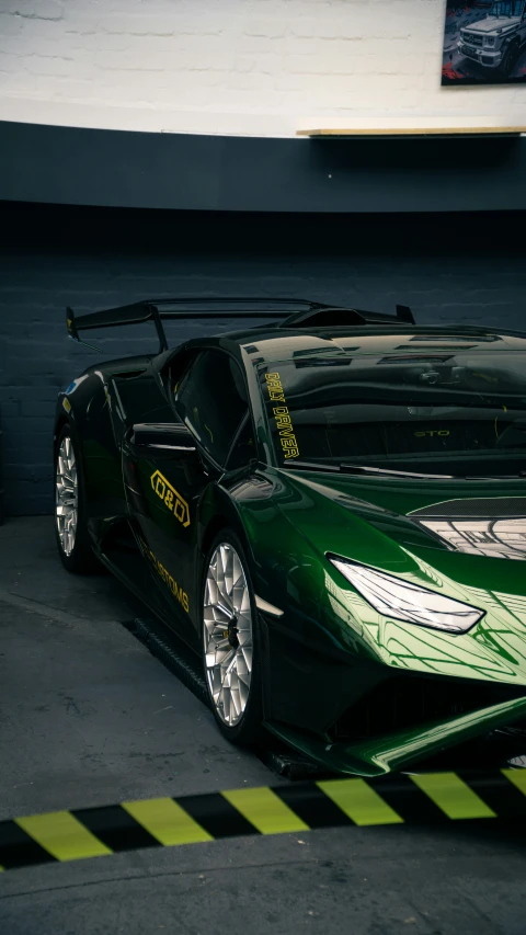 a green colored sports car parked inside a garage