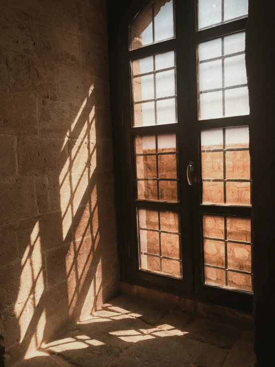 a large open window that is by a stone wall