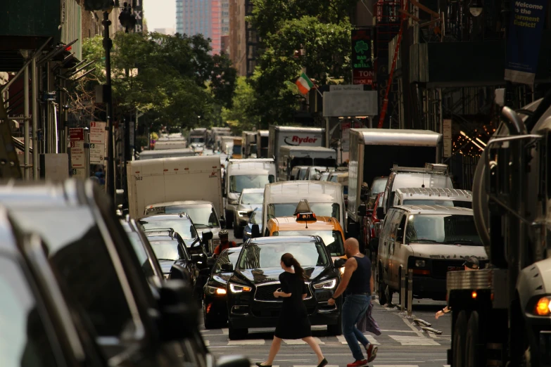 the people are crossing the street on a busy street