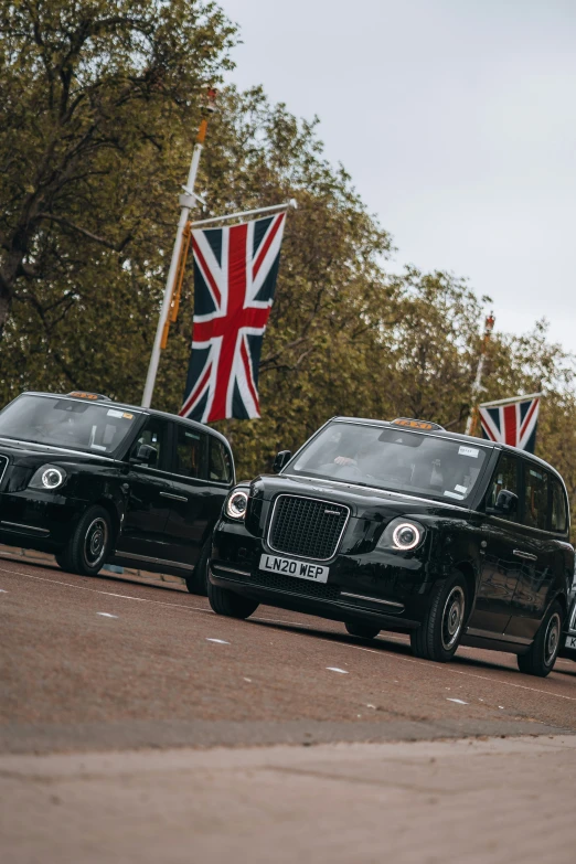 a black limo parked next to another black suv with a british flag on it
