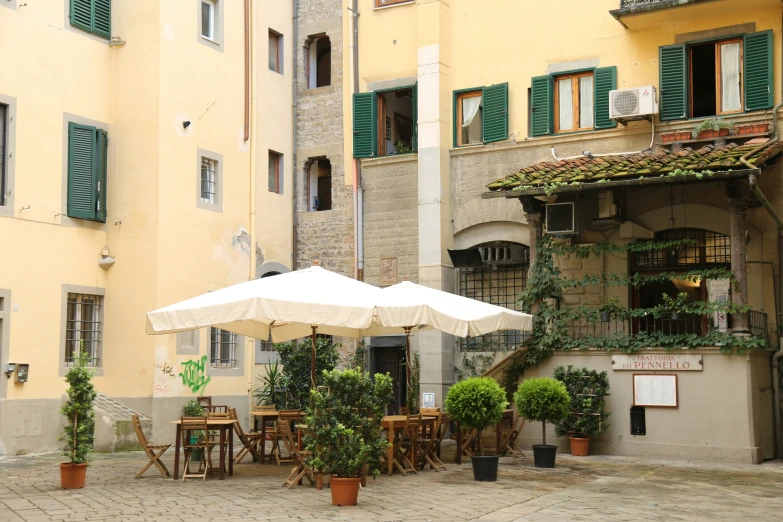 outdoor seating area with tables and umbrellas near building