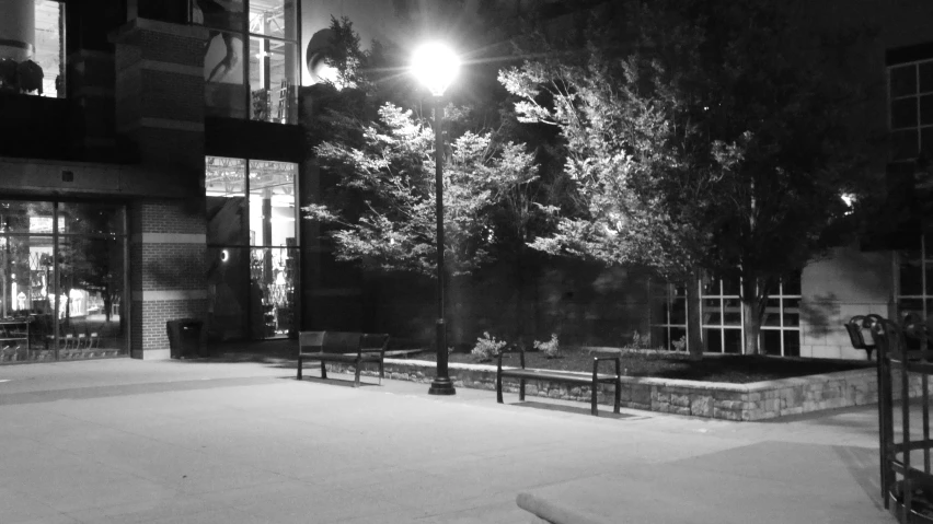 this is the entrance to a building with a park bench under a street lamp