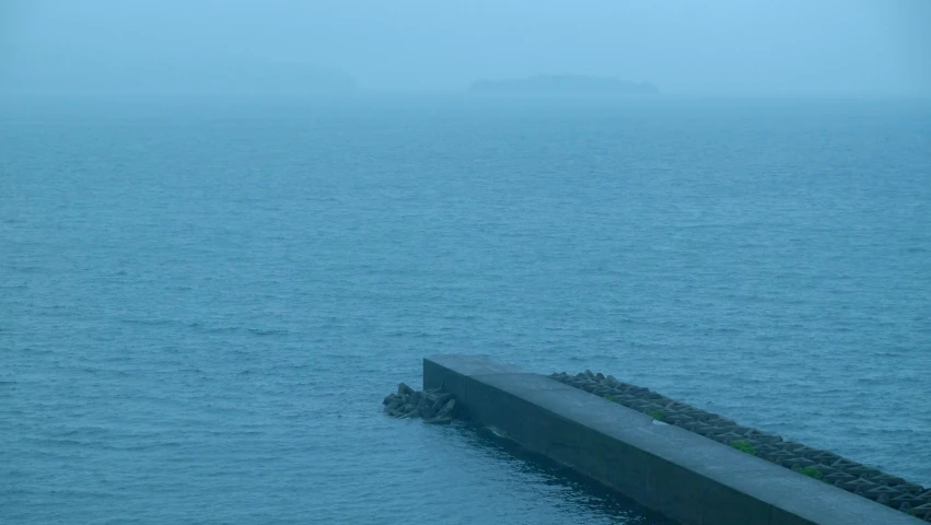 a long bridge with the sea in the background