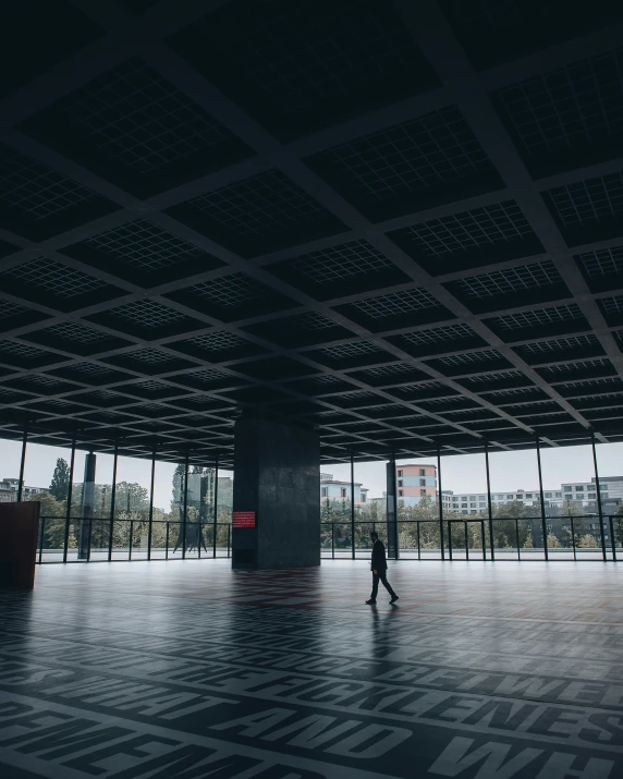 a person in an empty room surrounded by windows