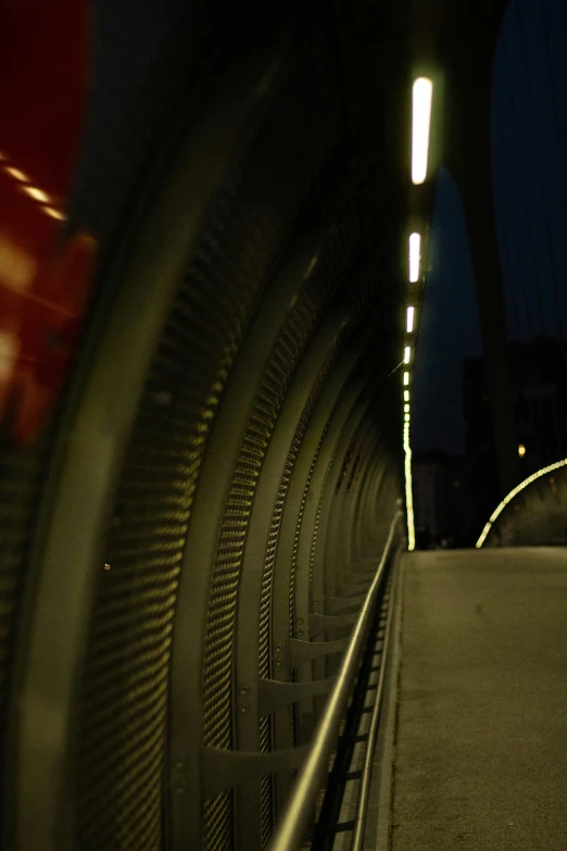 a woman is standing on the bottom of a bridge at night