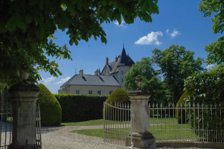 a tall house sits next to a white and grey fence