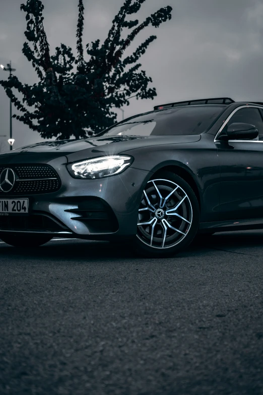 black mercedes c - class parked next to trees