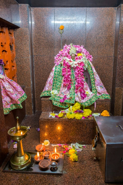 an indian shrine with various items and candles