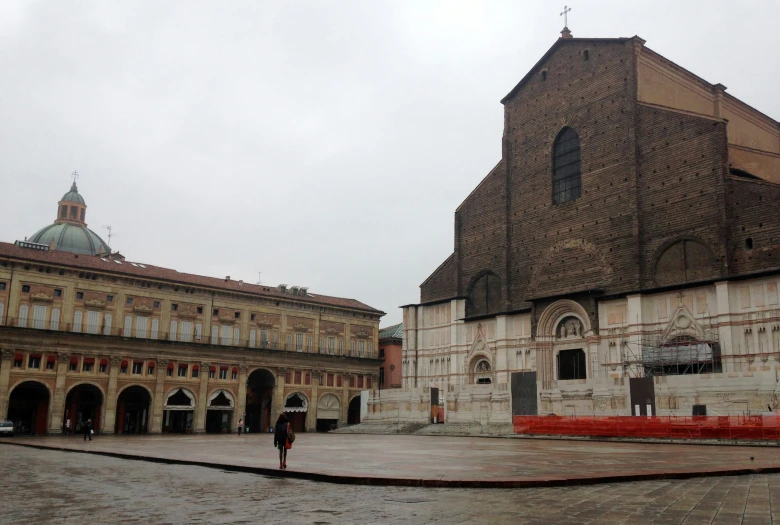 some people walking around in a courtyard and a big building