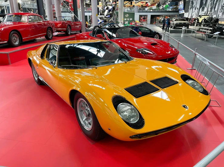 two sports cars sit in the center of an assembly line