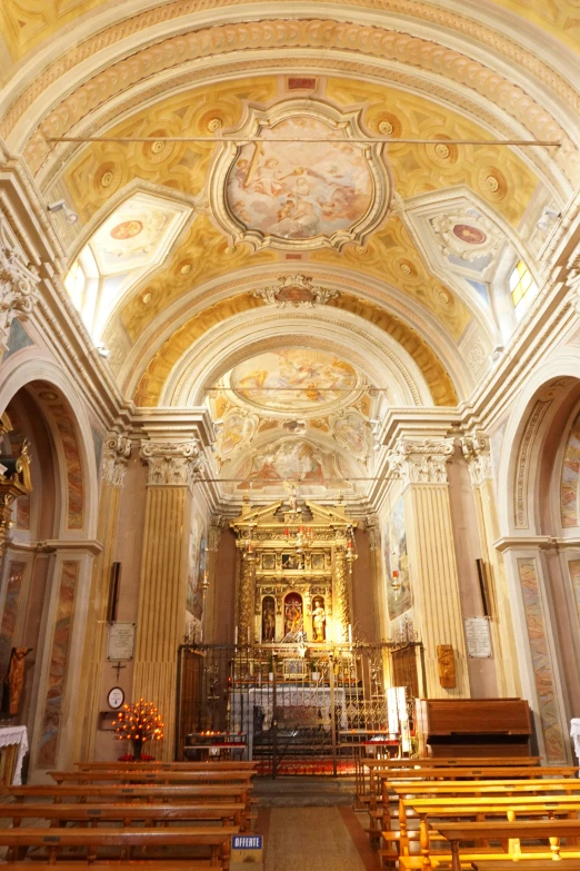 a church is shown with wooden benches and gold and white walls