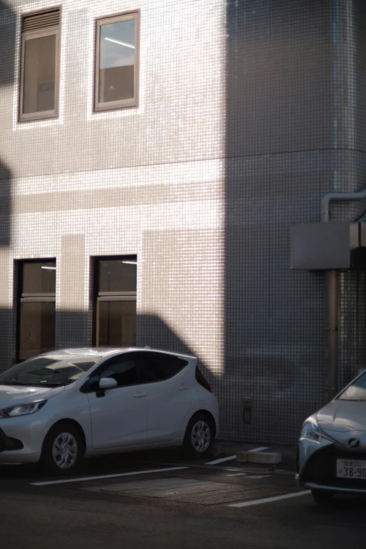 two cars are parked on a street next to a building