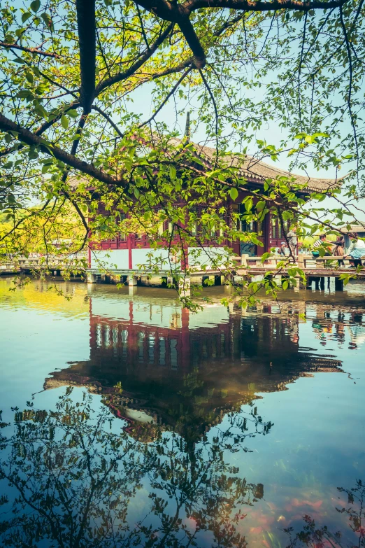 a reflection of a boat house in the water