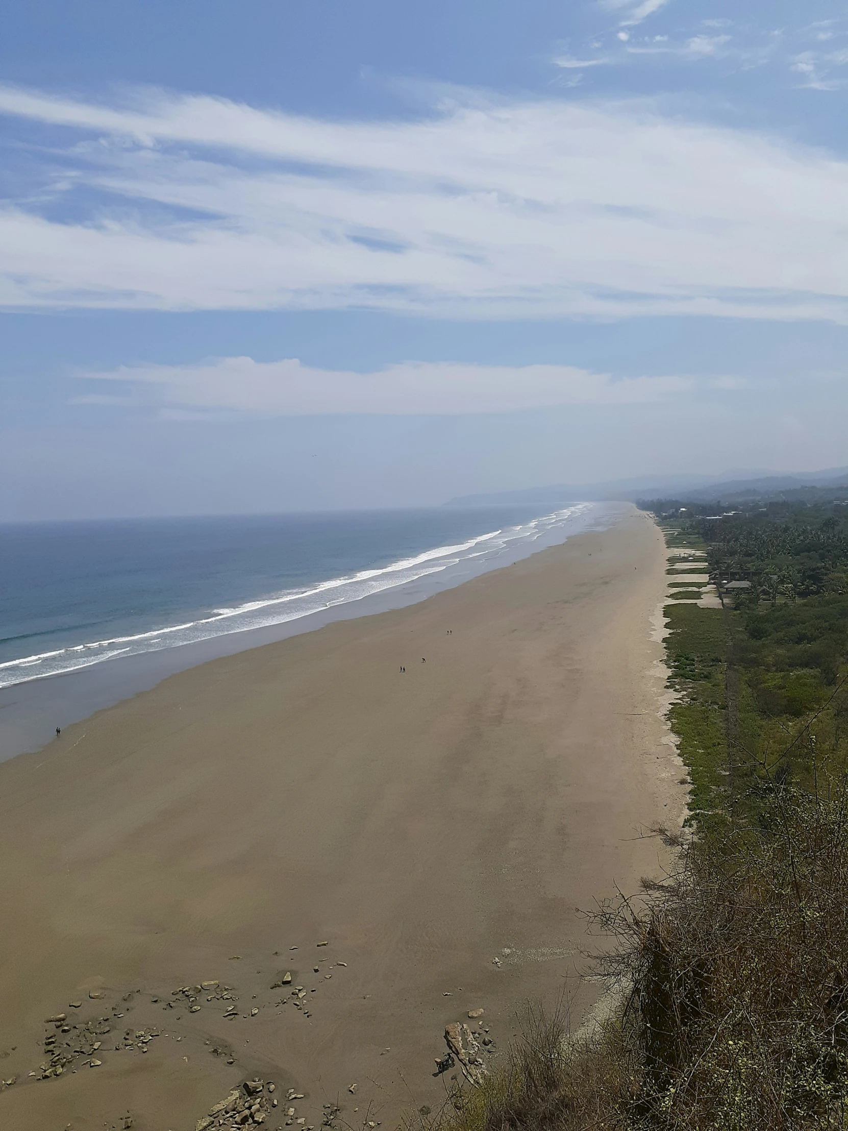 a beach with the ocean and sand blowing in