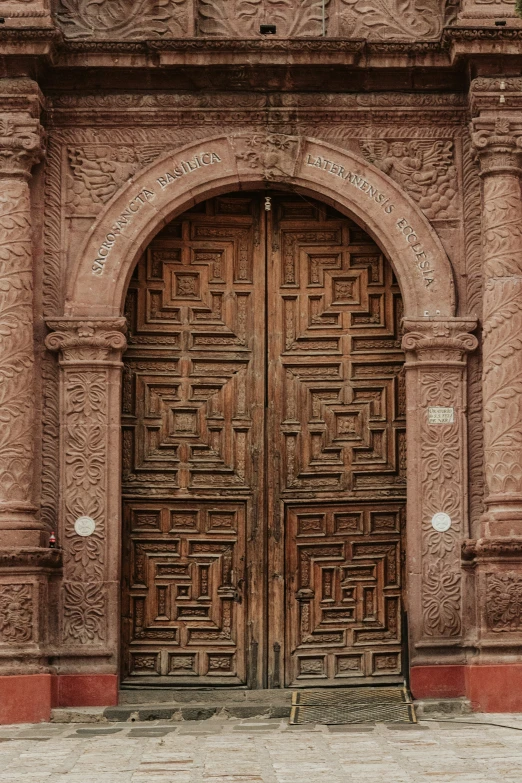 large decorative doors to an old church, with brickwork on the outside