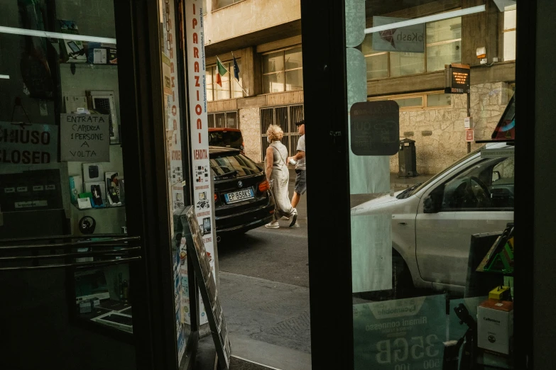 the woman walks by the store door while another waits